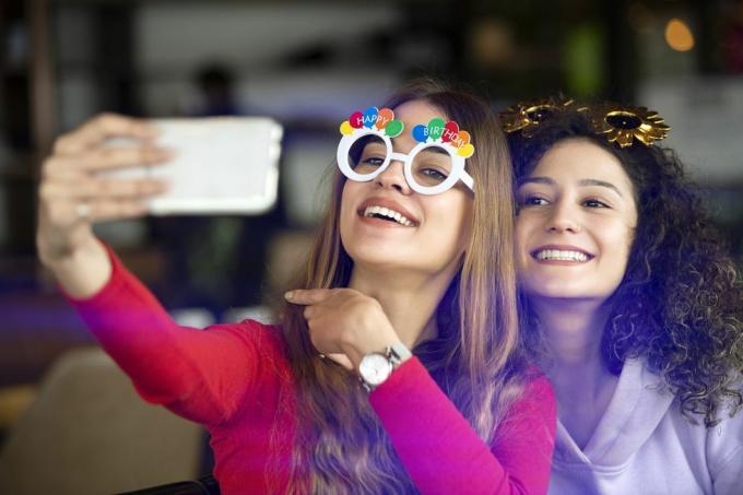 filles drôles prenant des selfies à la fête d'anniversaire
