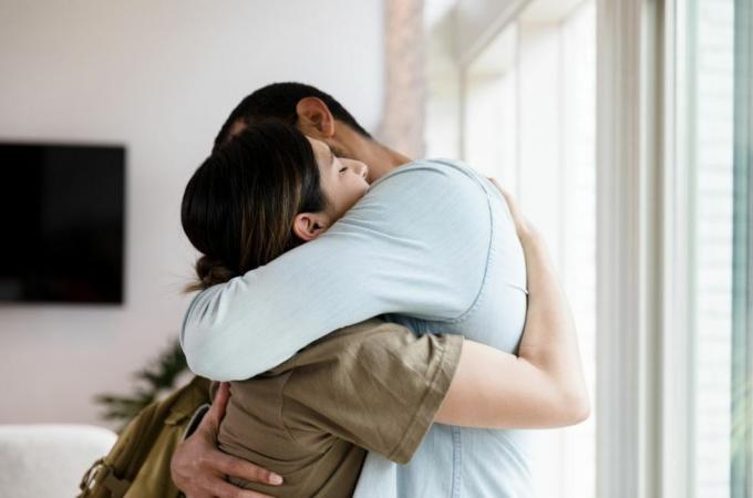 triste femme soldat mi-adulte embrasse son mari au revoir alors qu'elle part pour le service militaire