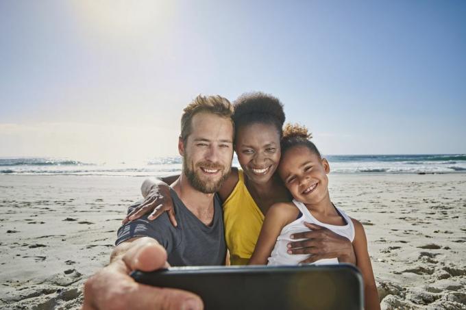 famille prenant un autoportrait sur la plage