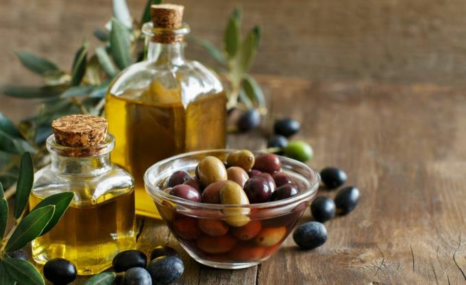 Huile d'olive et olives sur fond de bois