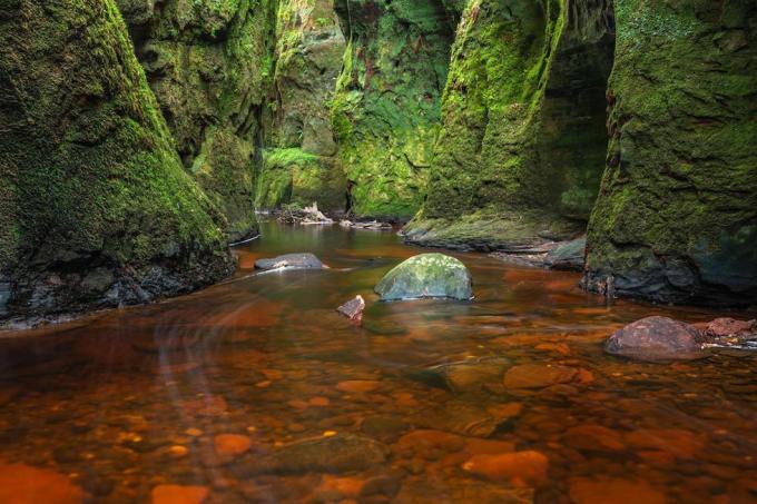 Rivière rouge sang dans une gorge verte. Devil's Pulpit, Finnich Glen, près de Killearn, Ecosse, Royaume-Uni