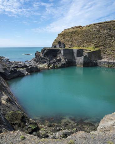 élément bien connu dans le parc national de la côte du Pembrokeshire, une ancienne carrière inondée par la mer pour créer une piscine d'un bleu profond, vestiges des vieux bâtiments au bord de l'eau