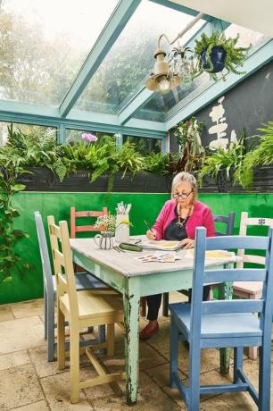 Annie Sloan dans un salon de jardin vert vif dans sa maison d'Oxford