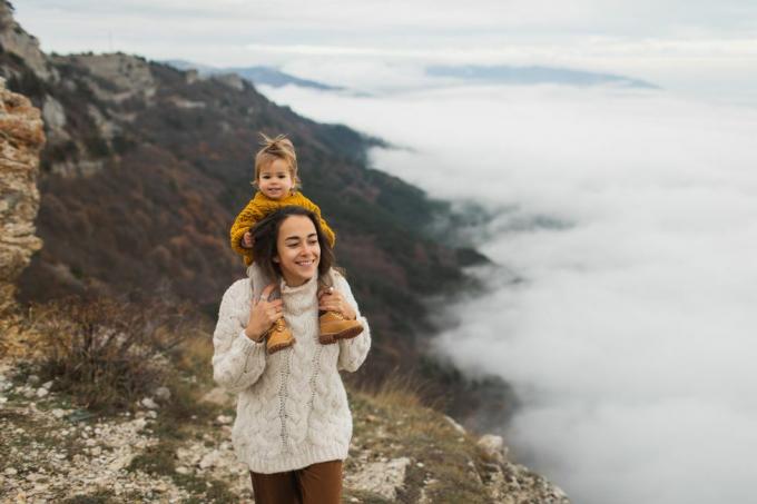 jeune femme heureuse avec sa petite fille en bas âge profitant ensemble d'un enfant assis sur le cou vivant simplement et en harmonie avec la nature d'automne