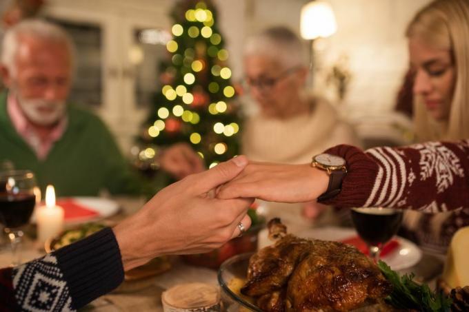 famille heureuse, les yeux fermés, se tenant la main et priant ensemble