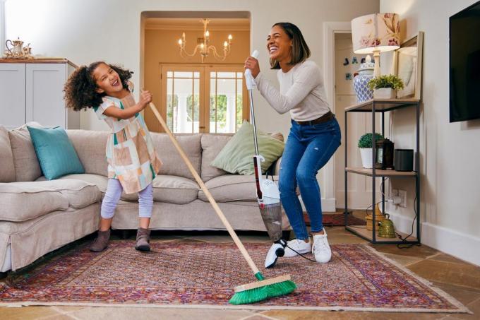 photo d'une mère et de sa fille s'amusant en nettoyant le salon