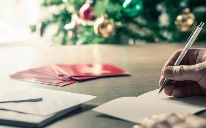 écrire des messages de carte de Noël devant un arbre de Noël