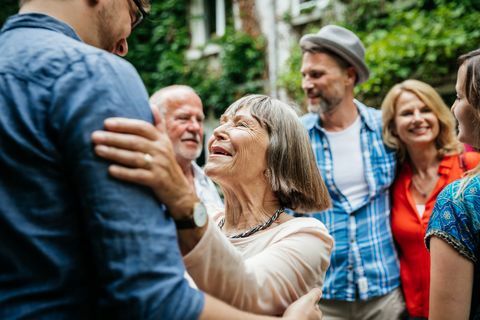 Personnes âgées Dame saluant les membres de la famille dans la cour