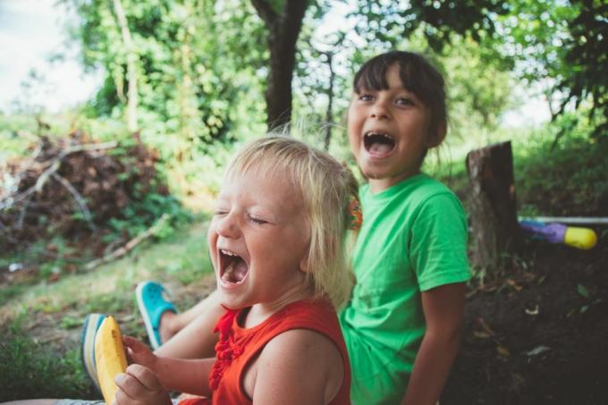 blonde happy smiling little girl excité rire les mains dans la bouche