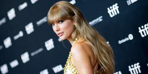 Taylor Swift regardant par-dessus l'épaule sur le tapis rouge en robe dorée