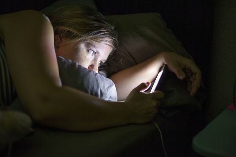 Femme regarde, à, téléphone intelligent, dans lit