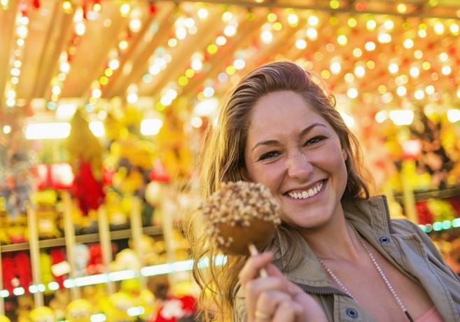 USA, Maine, Rockland, femme tenant une pomme au caramel à la fête foraine