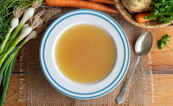 Bouillon d'os de poulet dans une assiette avec des légumes