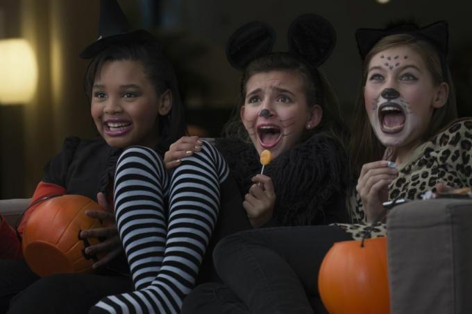 filles en costumes regardant un film d'horreur ensemble à Halloween
