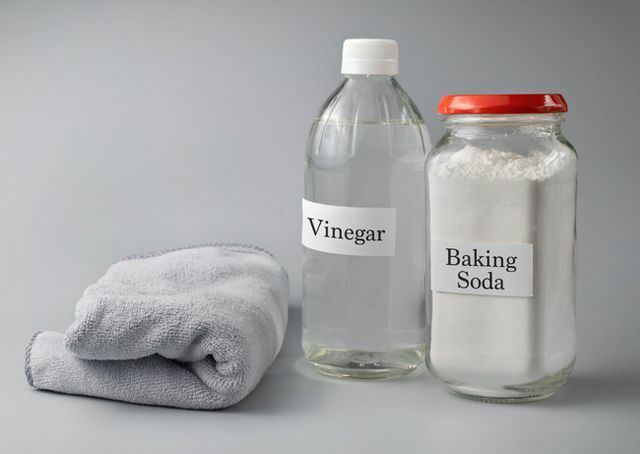 gros plan du texte du vinaigre et du bicarbonate de soude sur une bouteille en verre sur fond gris