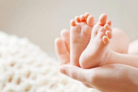 Pieds de bébé dans les mains de la mère. Maman et son enfant.