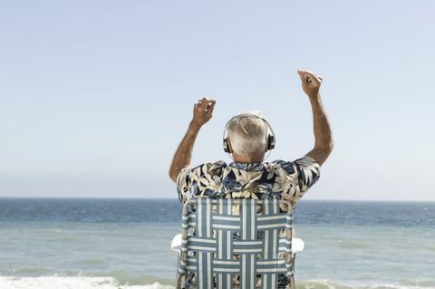 Heureux vieil homme écoutant de la musique avec vue sur la mer