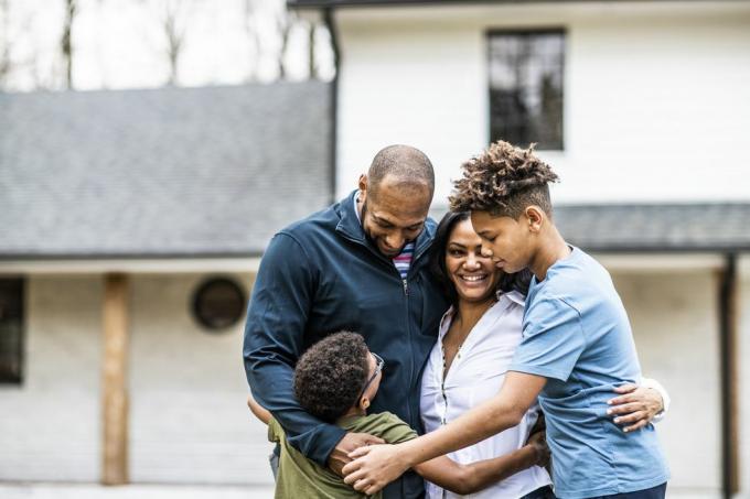 portrait de famille devant une maison d'habitation