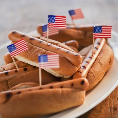 petits drapeaux américains dans des hot-dogs grillés sur des petits pains