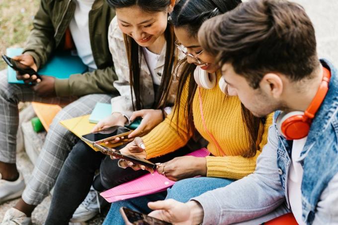 divers jeunes étudiants adolescents s'amusent en utilisant le téléphone portable dans l'éducation sur les campus universitaires, les millénaires et le concept de médias sociaux