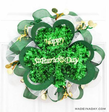Couronne faite de guirlandes vertes, ruban, toile de jute et plus en forme de trèfle, avec des lettres en or lisant le jour de la Saint-Patrick