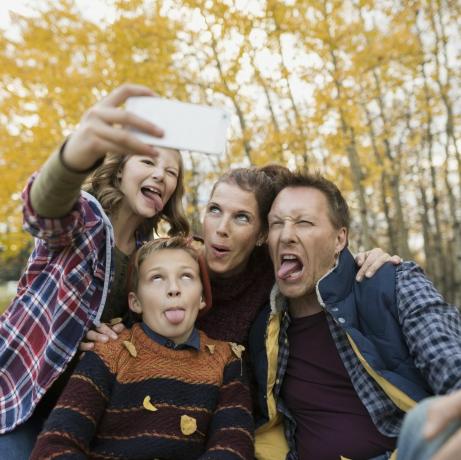 Famille stupide prenant selfie faisant des visages parc d'automne