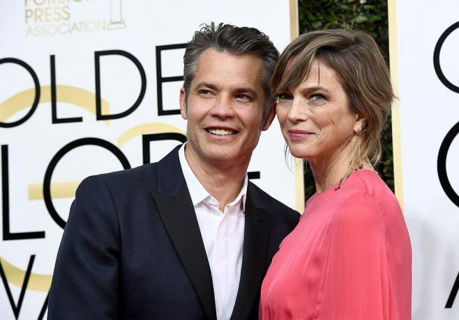 olyphant en costume bleu marine et bouton blanc, couteau en robe de soie rouge, pose sur le tapis rouge à la 74e cérémonie des Golden Globe Awards de la NBC