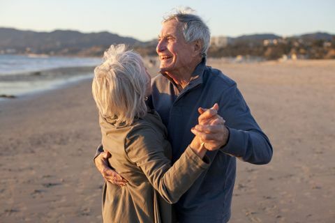 Vieux couple dansant sur la plage en hiver